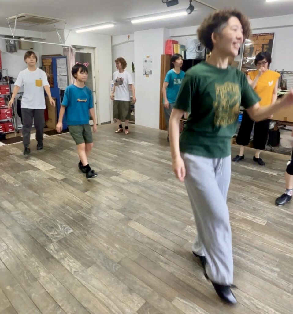 笑顔でタップダンスのステップを踏む